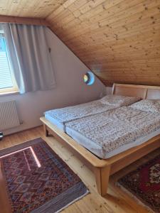 a bed in a room with a wooden ceiling at Singer-Hof in Krumpendorf am Wörthersee