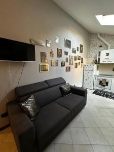 a black couch in a living room with a tv at La casa magica in Cuggiono