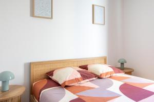 a bedroom with a bed with a colorful comforter and pillows at Romantic getaway with jacuzzi, Garden view in Mulhouse