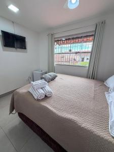 a bedroom with a large bed and a window at Aeroporto e praia Studio Casal in Vitória