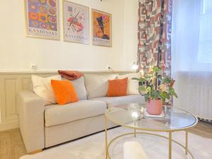 a living room with a couch and a glass table at Le Haussmann - Centre Historique, Chic & Terrasse in Saint-Brieuc
