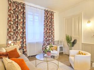 a living room with a couch and a table at Le Haussmann - Centre Historique, Chic & Terrasse in Saint-Brieuc +16 photos
