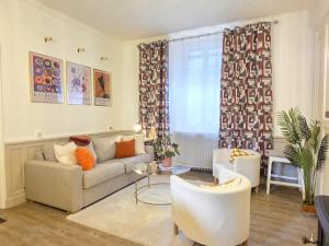 a living room with a couch and a table at Le Haussmann - Centre Historique, Chic & Terrasse in Saint-Brieuc