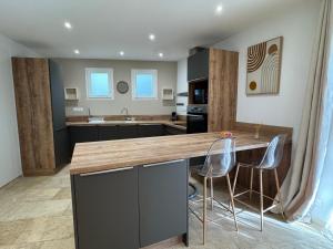 a kitchen with a counter and two stools at SUPERBE T2 moderne - ENTREE DE VILLE - PARKING PRIVE in Ajaccio