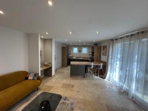 a living room with a couch and a kitchen at SUPERBE T2 moderne - ENTREE DE VILLE - PARKING PRIVE in Ajaccio