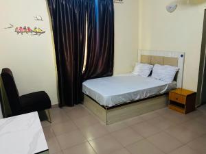 a small bedroom with a bed and a window at Elite Hotel in Ekpoma