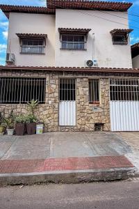 a stone house with two white doors and windows at Aeroporto e praia Studio Casal in Vitória