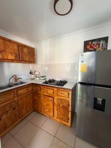 a kitchen with wooden cabinets and a stainless steel refrigerator at Cactus & Cove Villa in Santa Cruz