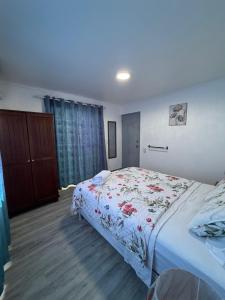 a bedroom with a bed with a floral bedspread at Cactus & Cove Villa in Santa Cruz