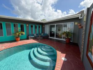 a swimming pool in front of a house at Cactus & Cove Villa in Santa Cruz