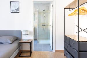 a bedroom with a shower and a bed and a table at Romantic getaway with Jacuzzi, Downtown in Mulhouse +14 photos