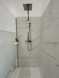 a bathroom with a shower with white marble tiles at Maison de ville in Libourne