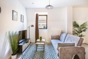 a living room with a couch and a tv at Romantic getaway with Jacuzzi, Downtown in Mulhouse