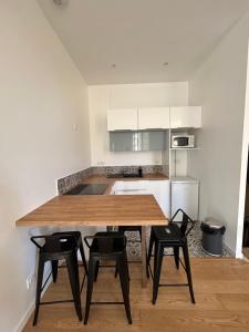 a kitchen with a wooden table and four chairs at Maison de ville in Libourne