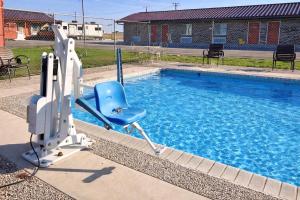 a blue chair sitting next to a swimming pool at Regency Inn Hondo in Hondo