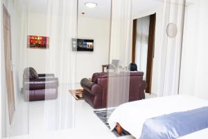 ein Schlafzimmer mit einem Bett, einer Couch und einem Stuhl in der Unterkunft Premium HOTEL in Douala + 1 Foto