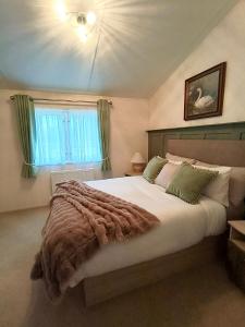 a bedroom with a large bed and a window at 10 lochview in Moffat