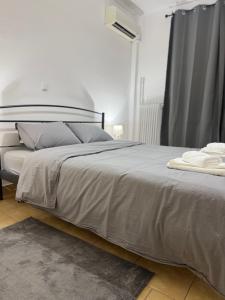 a bedroom with a large bed with white sheets and pillows at Dimitras Apartment with 3 bedrooms Elefsis in Eleusis