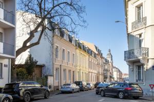 a row of cars parked on a street with buildings at Romantic getaway with Jacuzzi, Downtown in Mulhouse