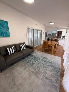 a living room with a couch and a dining room at Upper Esplanade Oceanview Escape in Bunbury