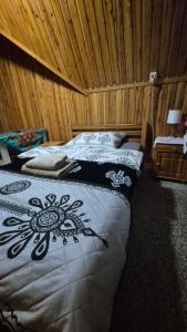 two beds in a room with wooden walls at Limba in Ząb
