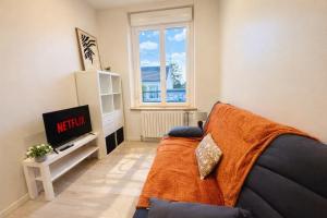 a living room with a couch and a tv at Duplex 4 personnes proche gare in Reims