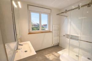 a bathroom with a glass shower and a sink at Duplex 4 personnes proche gare in Reims