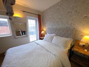 a bedroom with a large white bed with a window at The Mews @ The Pheasant in Ironbridge