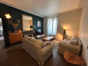a living room with two couches and a mirror at Grande maison Albuconis in Saint-Oradoux-près-Crocq