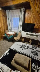 a bedroom with a bed and a television and a table at Limba in Ząb