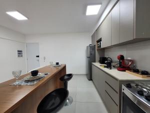 a kitchen with a counter and a black chair in it at Lavit 92 - Conforto, estilo e lazer com piscina e academia in Bauru +48 photos