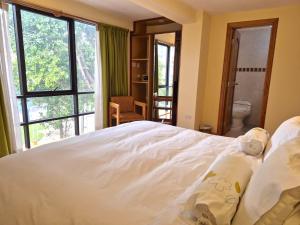 a bedroom with a large white bed and a window at Florida del Inca Hotel in Cusco