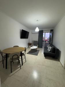 a living room with a table and a couch at Dimitras Apartment with 3 bedrooms Elefsis in Eleusis