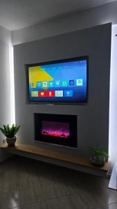 a flat screen tv on a wall with a fireplace at Apartment 1 by Villa Ceni in Elbasan