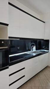 a kitchen with black and white cabinets and a sink at Apartment 1 by Villa Ceni in Elbasan +6 photos