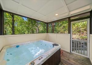 a large hot tub in a room with windows at Rustic Lodge - Pet-Friendly Cabin with Hot Tub & Fire Pit in Pigeon Forge +18 photos