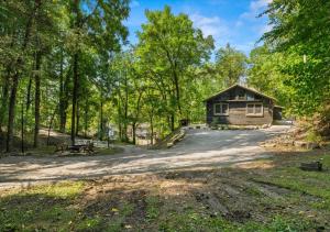 a cabin in the woods with a dirt road at Rustic Lodge - Pet-Friendly Cabin with Hot Tub & Fire Pit in Pigeon Forge