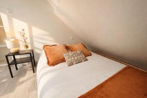 a bed with two pillows on it in a room at Duplex 4 personnes proche gare in Reims