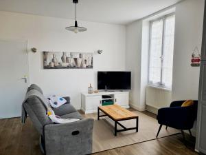 a living room with a couch and a tv at Maison tout confort avec jardin - CHANTILLY, SENLIS, PARC ASTERIX, PARIS CDG in Avilly-Saint-Léonard