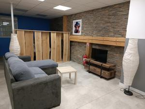 a living room with a couch and a television at Appartement original tout confort in Condamine