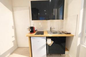 a small kitchen with a counter and a sink at Duplex 4 personnes proche gare in Reims