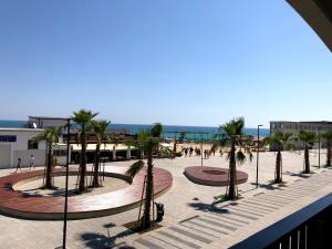 a plaza with palm trees and people on the beach at B&B La Finestra sui Trabocchi in San Vito Chietino +17 photos