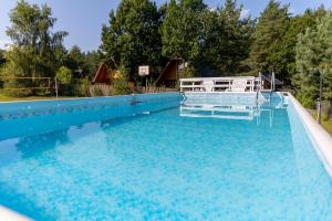 a large swimming pool with blue water at Słoneczna Przystań in Sasino +104 photos