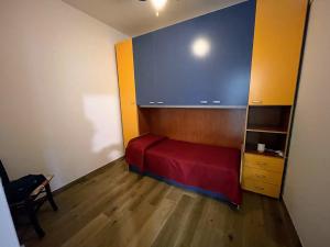 a small bedroom with a red bed and a book shelf at B&B La Finestra sui Trabocchi in San Vito Chietino