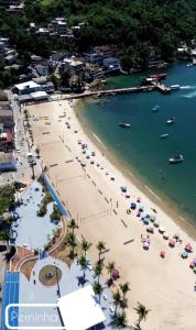 an aerial view of a beach with umbrellas at Charlotte Beach Inn in Mangaratiba