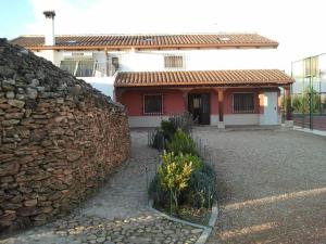 a red and white house with a stone wall at Casa rural EL BOMBO in Tomelloso