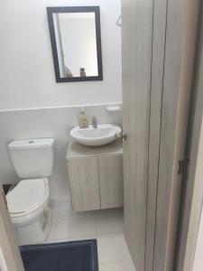 a bathroom with a toilet and a sink and a mirror at Balcones del Bosque 14 -402 in Restrepo +6 photos