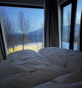 a bedroom with two beds and a large window at Lyngen Alps Inn in Lyngseidet