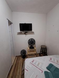 a bedroom with a bed and a flat screen tv at Suite Nomar in Brotas