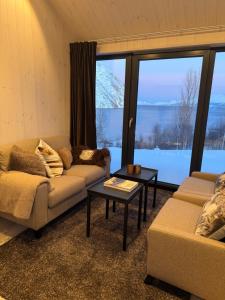 a living room with two couches and a table at Lyngen Alps Inn in Lyngseidet